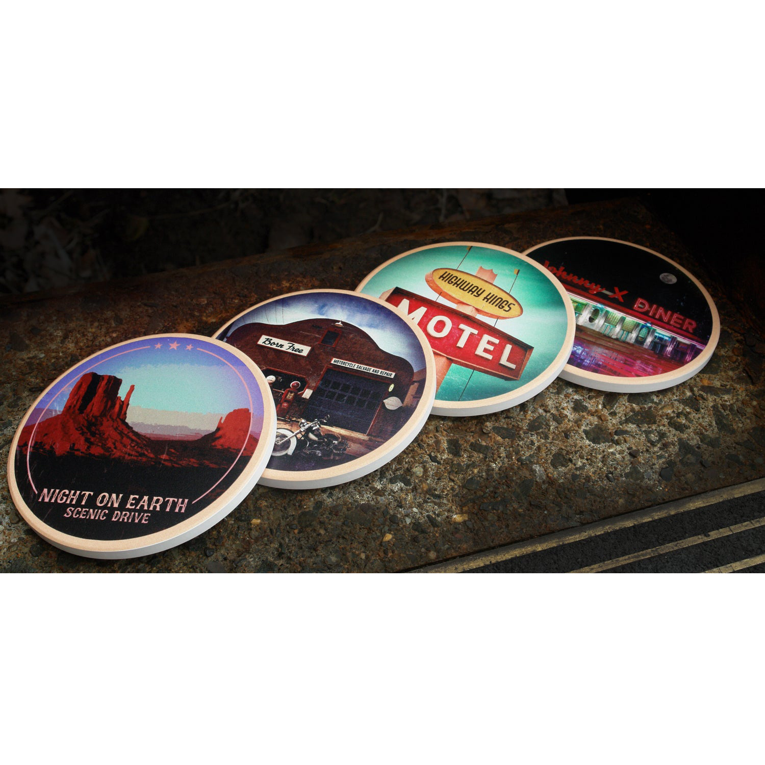 Image of 4 coasters lying on a grey granite background. The first coaster is a photo of red rocks in the desert and below that it says night on earth, scenic drive. The next one features a gas station with a motorcycle out front. The next coaster is a sign that says highway hings motel. The final coaster is a photo of a diner at night, a red neon sign says johnny x diner, and the sky has a full moon.